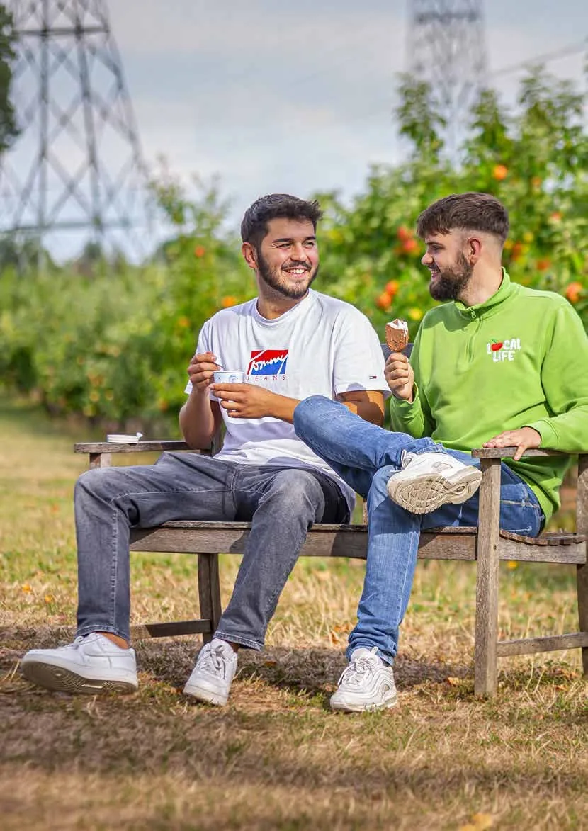 Valentin Steinbrenner mit einem Kollegen auf einer Bank zwischen Obstbäumen