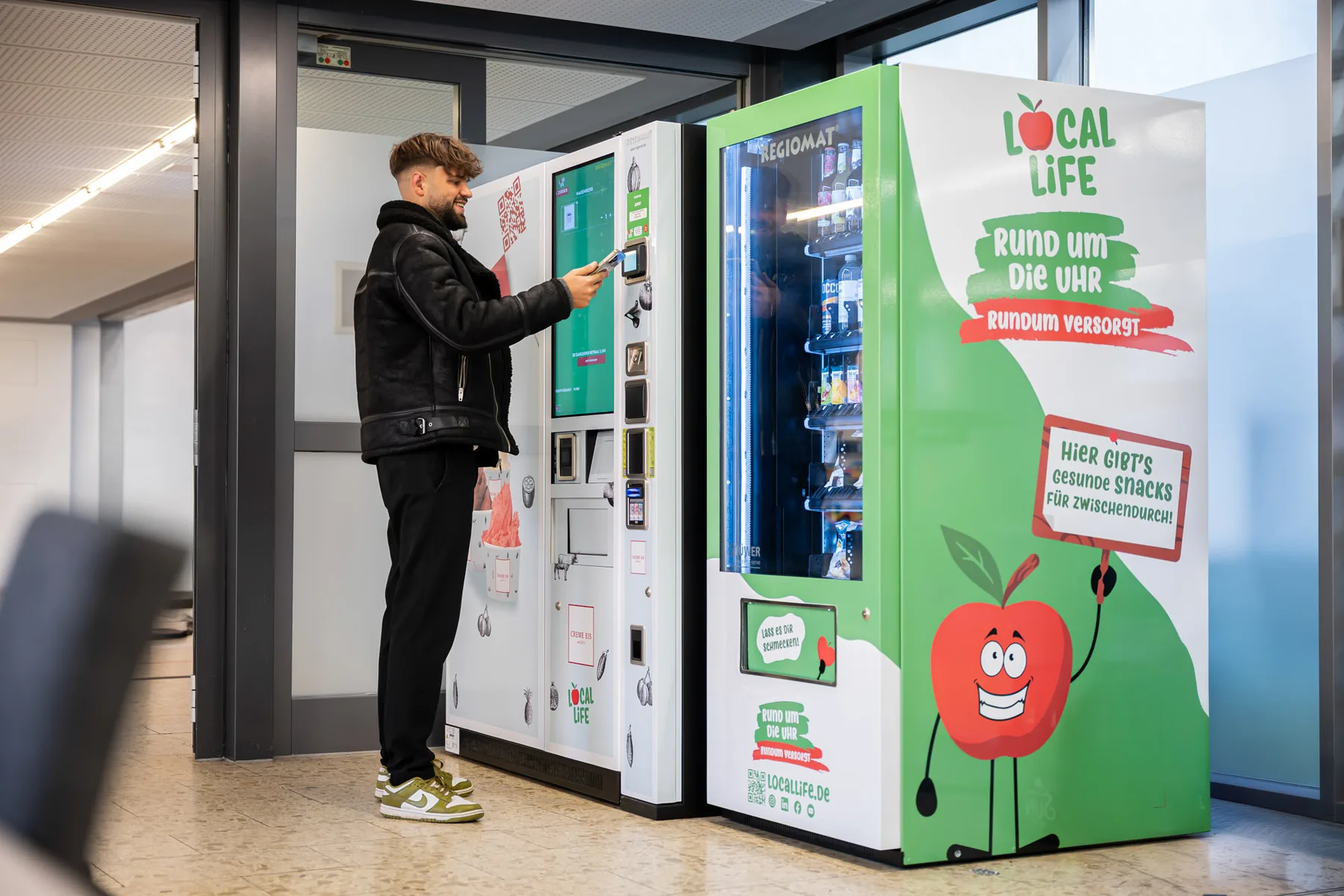 Ein Mann zieht sich am Local Life Automaten in der VHS Wuppertal ein Eis